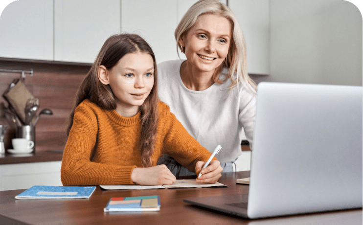 Una mujer y una niña están sentadas en una mesa, comprometidas con una computadora portátil, compartiendo un momento de aprendizaje o colaboración.