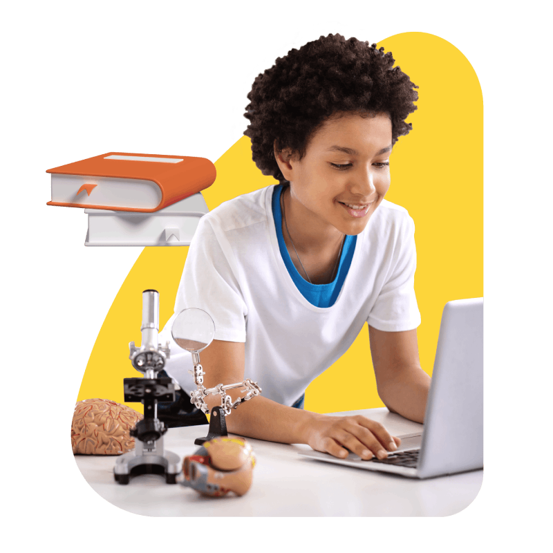 A boy focused on a laptop, surrounded by a microscope and various scientific tools, engaged in exploration and learning.