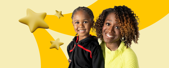 Two children smile brightly while proudly holding up a shiny gold star between them.